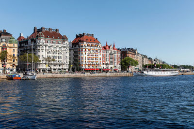 View of sea by buildings against clear sky