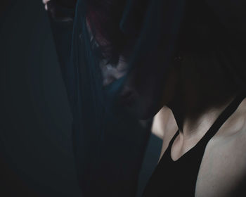 Close-up portrait of woman against black background