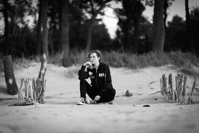 Young woman sitting on sand at beach