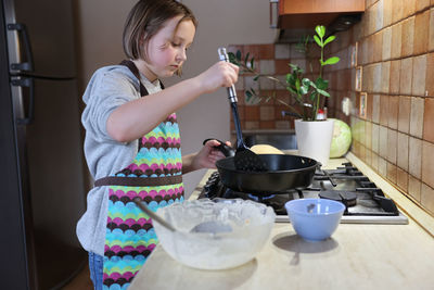 Mid adult woman having food at home