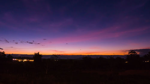 Silhouette landscape against dramatic sky during sunset