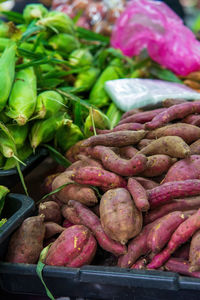 Sweet potatoes with other vegetables in a basket at the market.