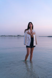 Portrait of a beautiful middle eastern woman standing in the water wearing a jacket