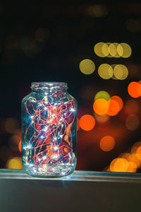 Close-up of lighting equipment on glass jar on table