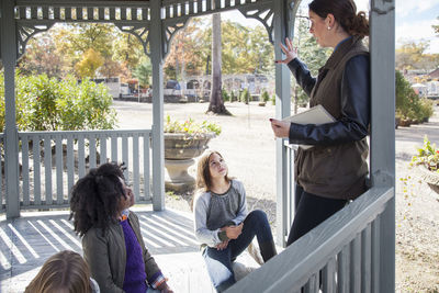 Teacher explaining students in gazebo during field trip