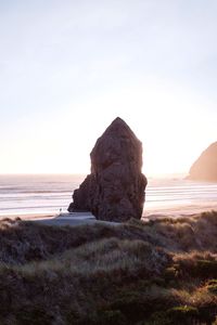 Rock formation at beach against sky