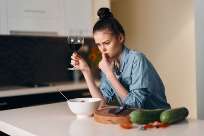 Young woman using mobile phone at table