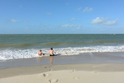 People on beach against sky