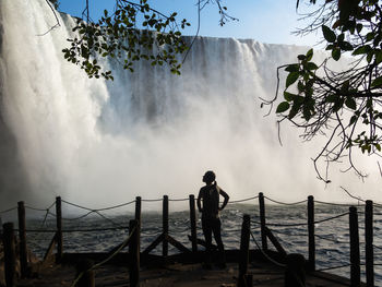 Rear view of silhouette of woman standing against lumangwe waterfall, zambia