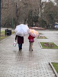 Rear view of women walking on footpath