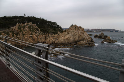 Scenic view of rocks by sea against sky