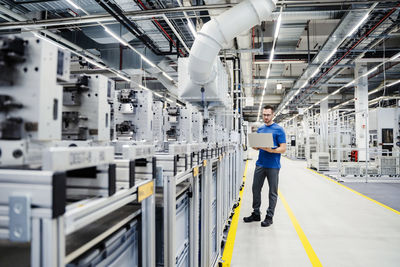 Technician using laptop on shop floor in a factory