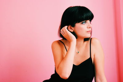 Portrait of woman standing against wall