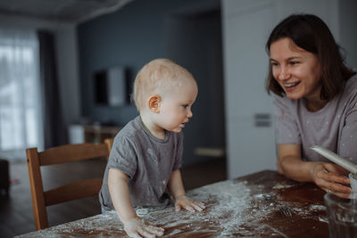 Smiling mother and cute boy with flour on face