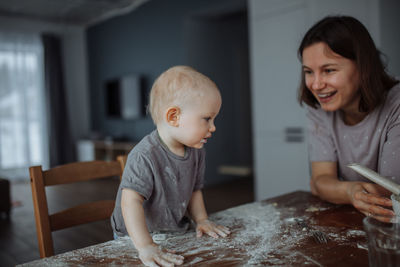 Side view of mother and daughter sitting at home