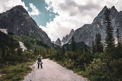 Rear view of women walking on mountain against sky