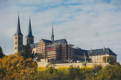 Low angle view of buildings against cloudy sky