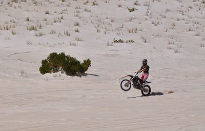 Woman riding bicycle on sand