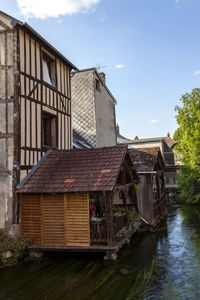 Houses by river against sky