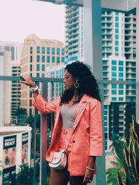 Woman standing against buildings in city