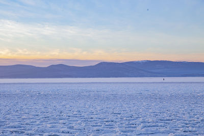 Scenic view of snowcapped mountains against sky during sunset