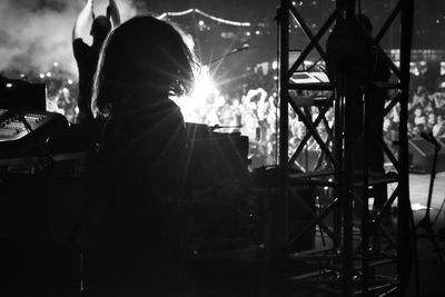 Rear view of silhouette person standing at music concert