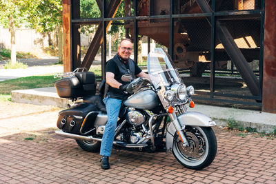 Biker posing smiling on his custom motorcycle