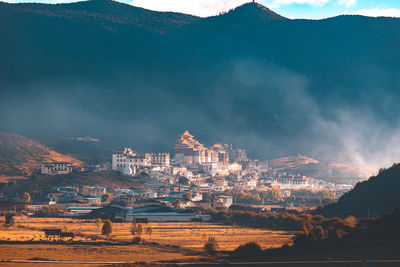 View of buildings in city against cloudy sky