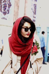 Beautiful woman wearing red scarf in city