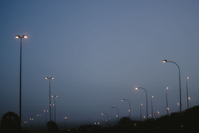 Street lights against clear sky at night