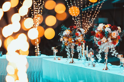 Bouquet flowers blooming in vase, decoration setting on wedding table, with bokeh lights