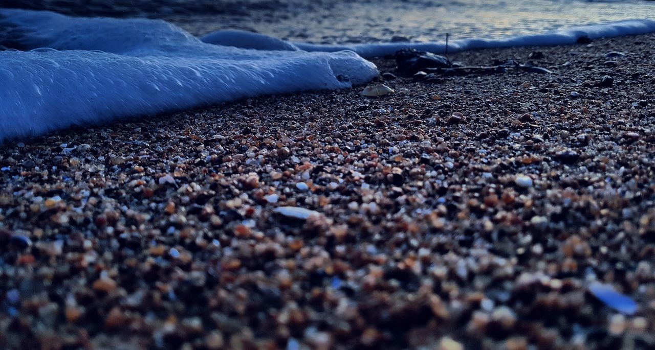 selective focus, surface level, land, day, beach, winter, snow, close-up, nature, no people, stone - object, outdoors, cold temperature, water, pebble, solid, sea, stone, sport, gravel