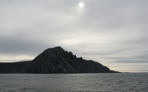 Scenic view of sea and mountains against sky