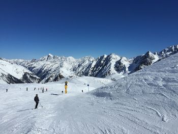 People skiing on snow covered landscape