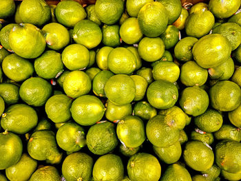 Stack of limes in display at grocery store for retail sale.