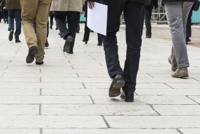 Low section of people walking on sidewalk