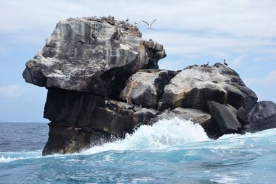 Rock formation in sea against sky