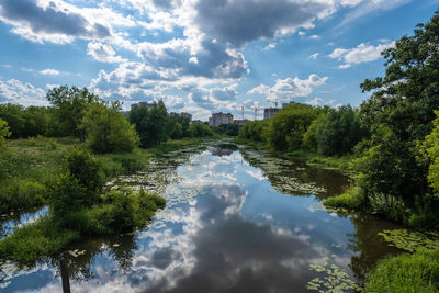 River uvod in the city of ivanovo with gray-white clouds reflected in the water on a summer day.
