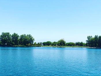 Scenic view of lake against clear blue sky