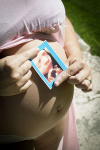 Midsection of woman holding mobile phone