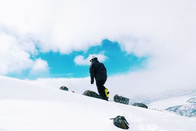 Man on snow covered mountain against sky