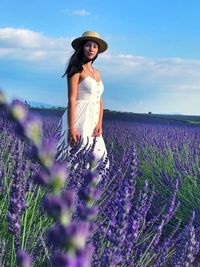 Full length of woman standing on field against sky