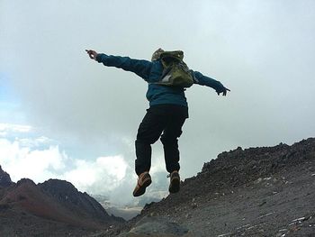 Low angle view of man jumping against sky