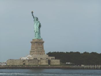 Statue of liberty against sky in city