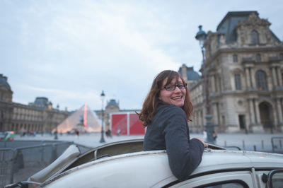 Portrait of woman standing on railing