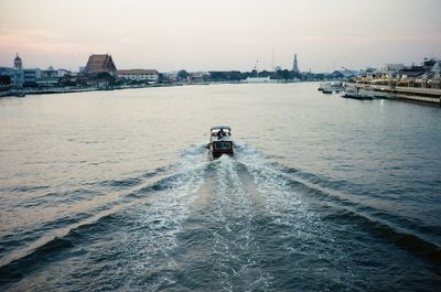 Boat in sea with city in background