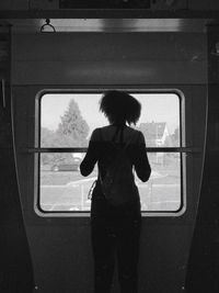 Full length of woman standing by train window