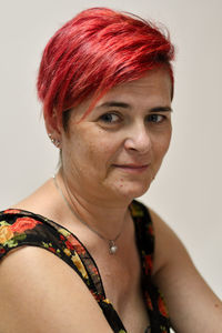 Portrait of woman with red hair against gray background