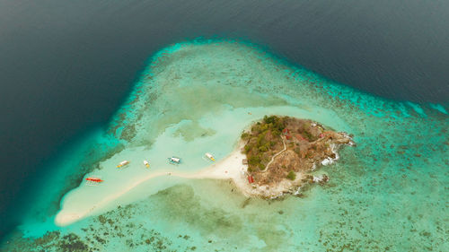 Aerial seascape tropical island and sand beach, turquoise water and coral reef. malacory island