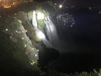 Low angle view of waterfall against sky at night